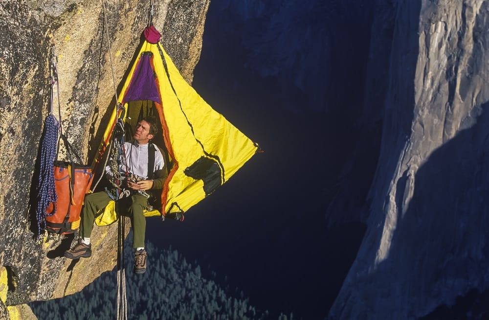 An extreme adventurer in Victoria, cliff camping in a tent.