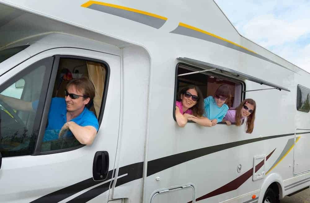 A group of people surveying the view out of the window of an RV during their AAA travel journey.