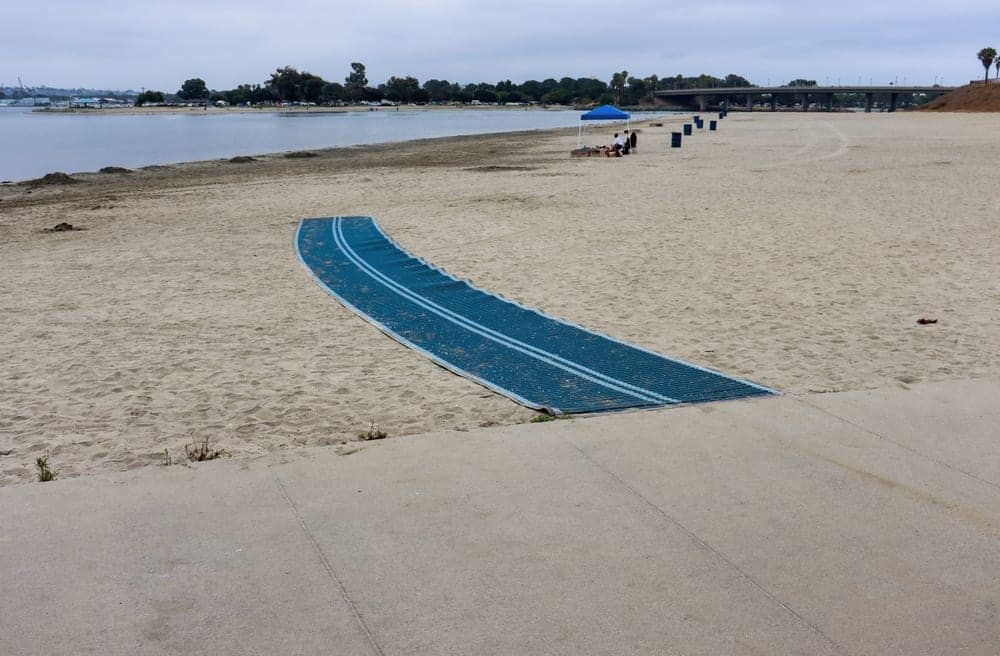 A blue tarp on the Provincial Park Beach next to a body of water.