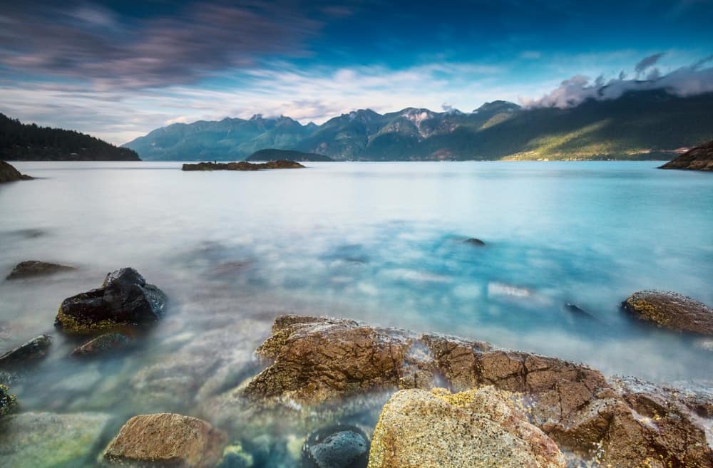 Hidden Gem: A lake with rocks and mountains in the background.