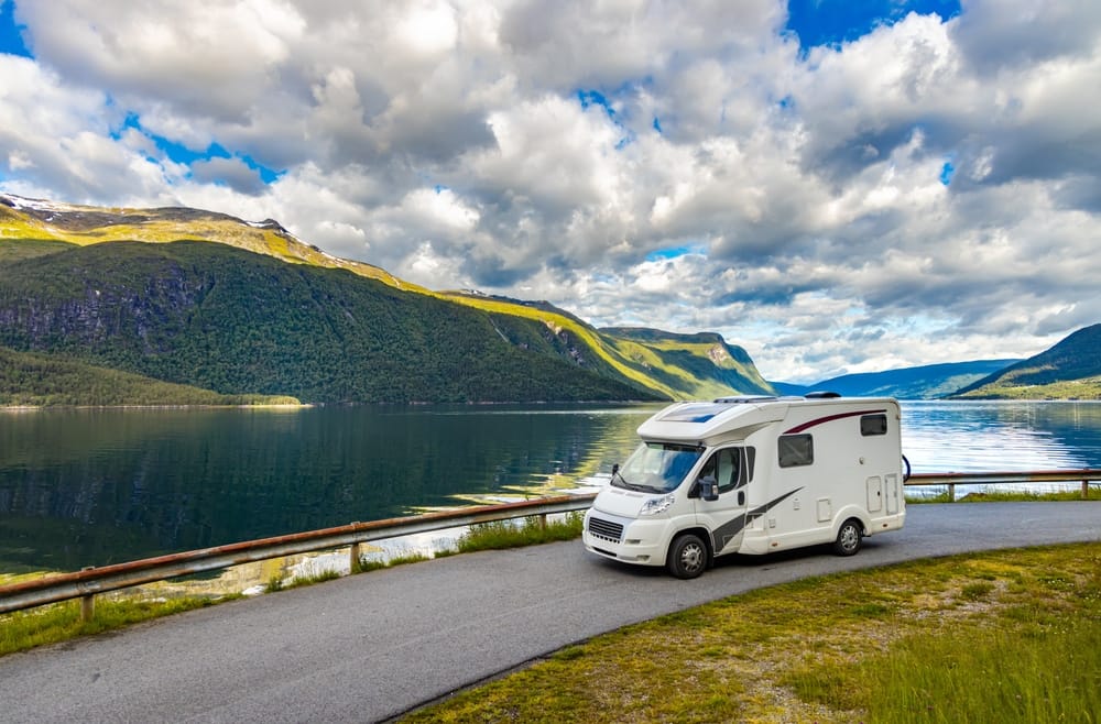 An RV parked near a beautiful lake.