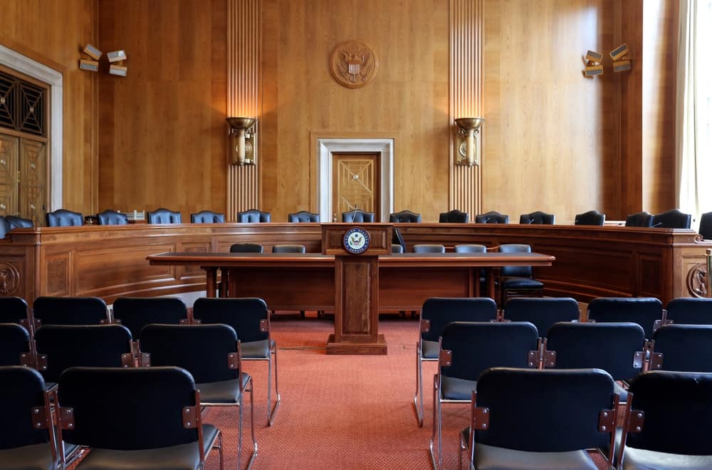 An empty courtroom with black chairs and wooden walls, as the country eagerly anticipates the voting date for the bipartisan infrastructure bill.