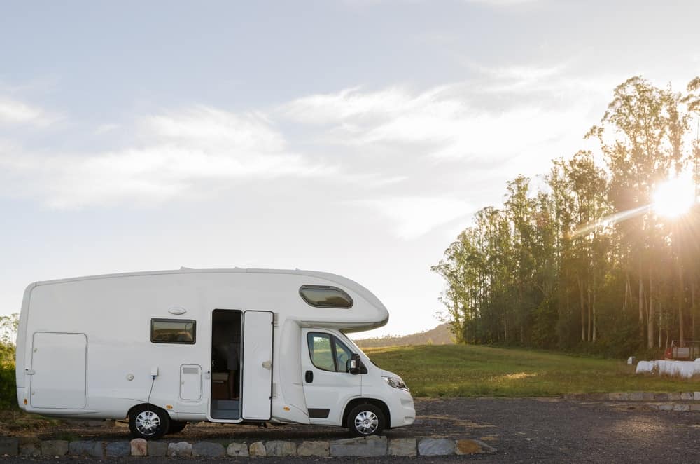 A white RV parked on a gravel road at one of the Idaho RV Parks.