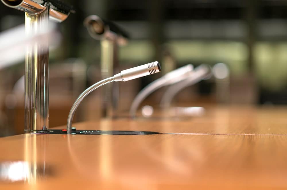 Microphones on a wooden table in a conference room at Board.