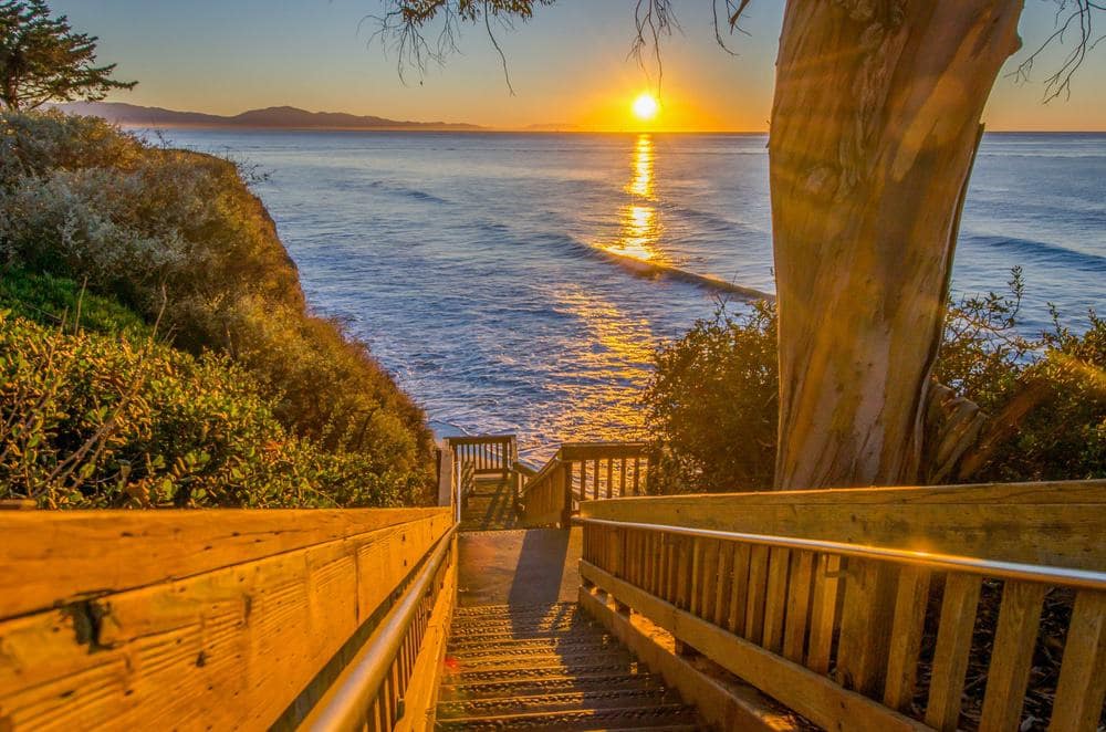 A wooden staircase leading to the ocean at sunset in Santa Barbara.