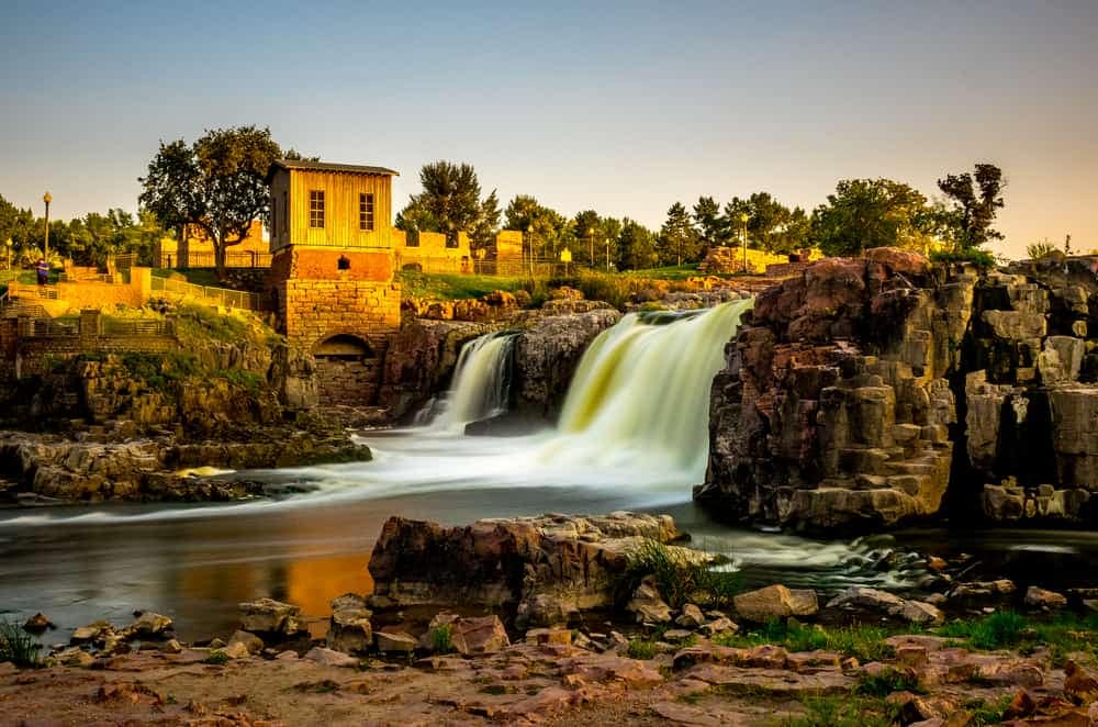 A waterfall in the middle of a rocky area located in South Dakota.