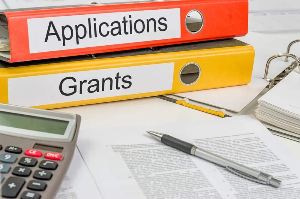 A stack of binders with the words applications and grants on them, providing improved accessibility for Big Hollow Recreation Area campsites.