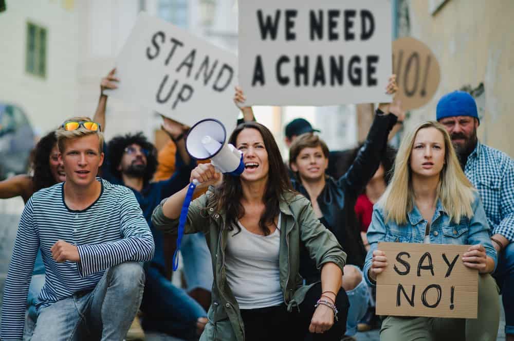 A group of people holding signs advocating for a change.