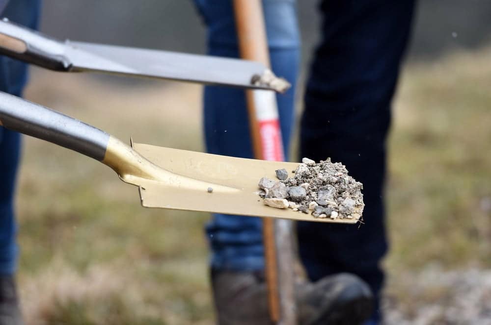 A shovel is being used to dig a hole in the ground at the groundbreaking of a new upscale RV resort in Hartsville.