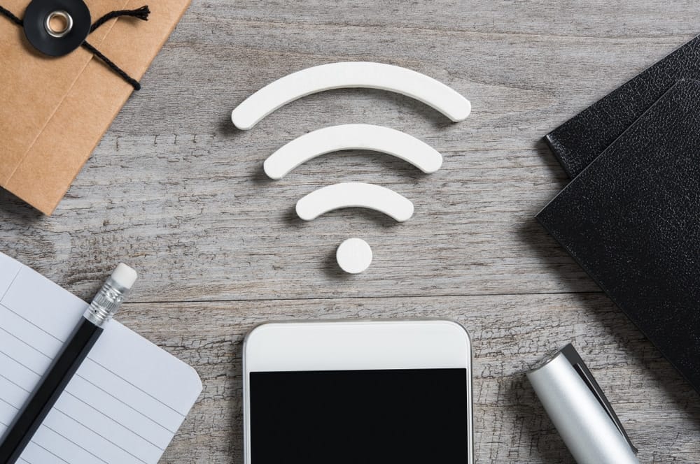 A smartphone with a wi-fi symbol on a wooden table, illustrating the seamless telecommunication capabilities for Kimberley businesses.
