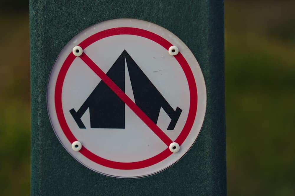 A no tent sign on a pole with grass in the background at a campground near Bull Shoals Lake.