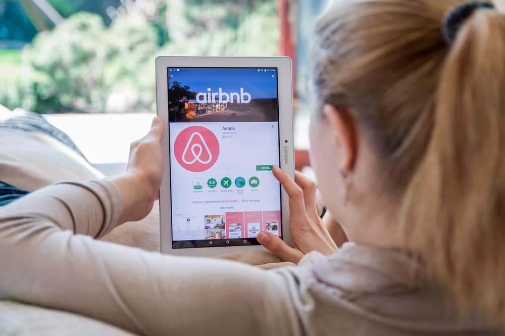 A woman in New York using an iPad with the Airbnb app on it.
