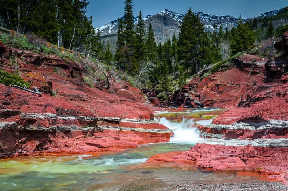 A stream flows through the red rocks of Waterton Lakes National Park during the busy summer season.