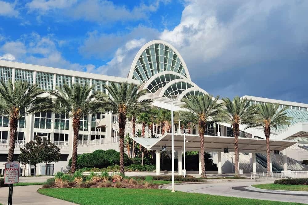 A large building with palm trees in front of it, situated at the venue of ARVC's Outdoor Hospitality Conference & Expo.