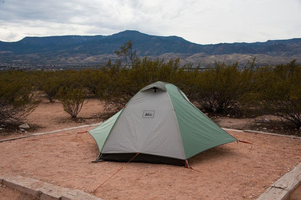 A tent set up in the desert with mountains in the background at Arizona State Parks.