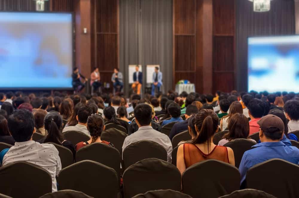 A large group of people in an auditorium watching a presentation on the RV Consumer's Path To Purchase.