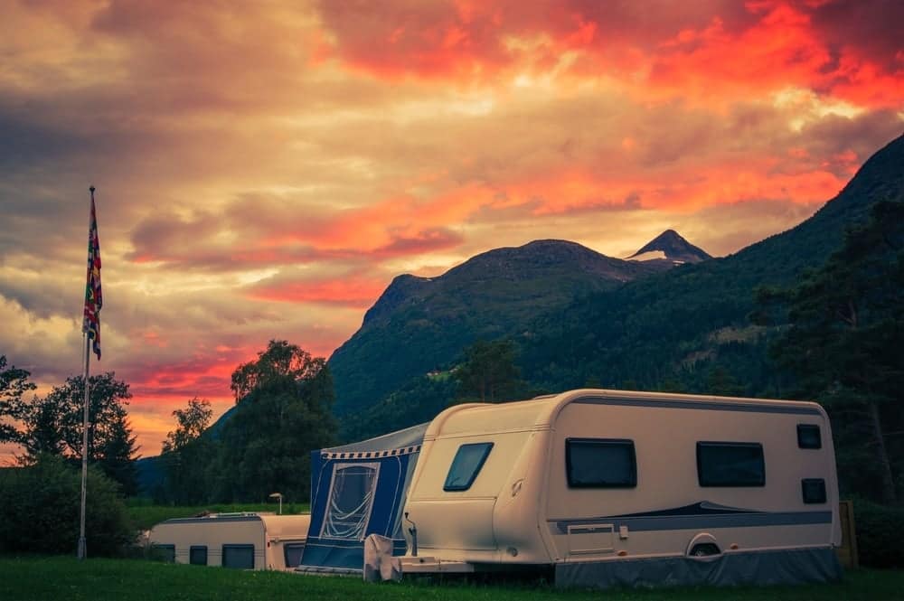 A proposed camper parked in front of a mountain at sunset, compliant with Orange County RV Park Regulations.