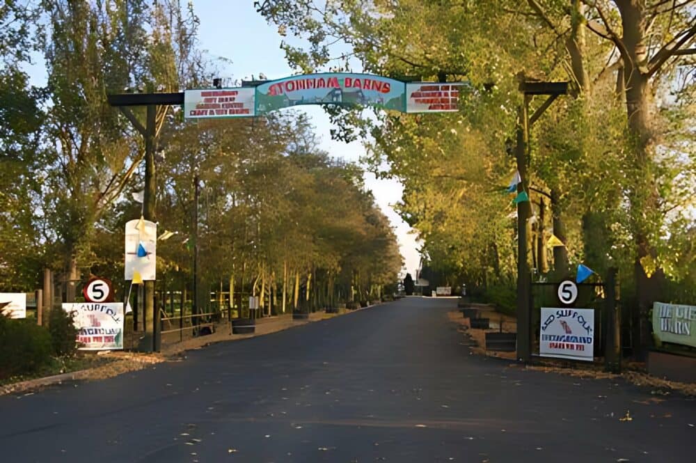 The entrance to Stonham Barns Park, offering leisure opportunities surrounded by trees and informative signs.