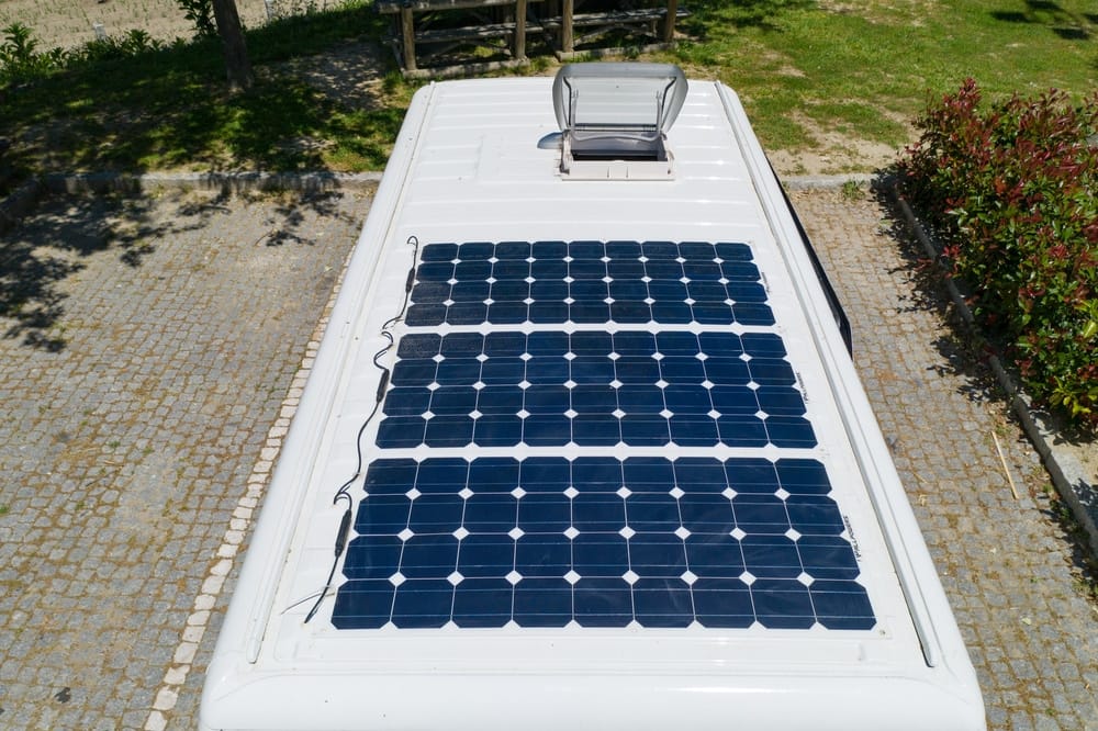 Solar panels on the roof of a white rv.