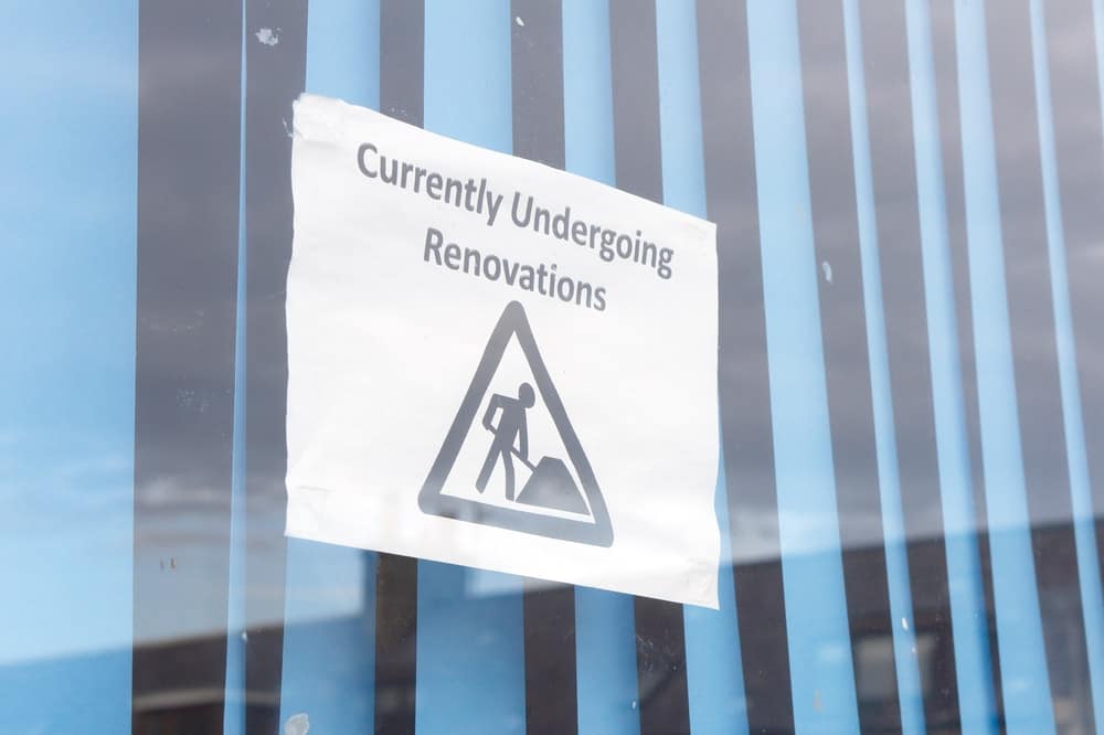 A sign on the side of a building that says currently under renovations.