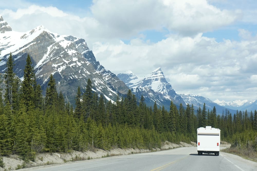 A Canadian RV expo showcasing the outdoor hospitality conference, featuring a picturesque road with mountains in the background.