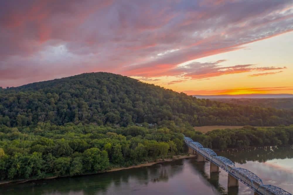 An aerial view of a bridge over a river at sunset in Virginia.