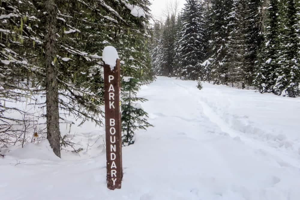 A snow covered trail in the Elk Valley with a sign in the snow.