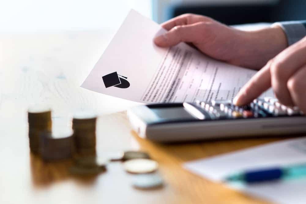 A man named Bill is holding a calculator and a piece of paper.