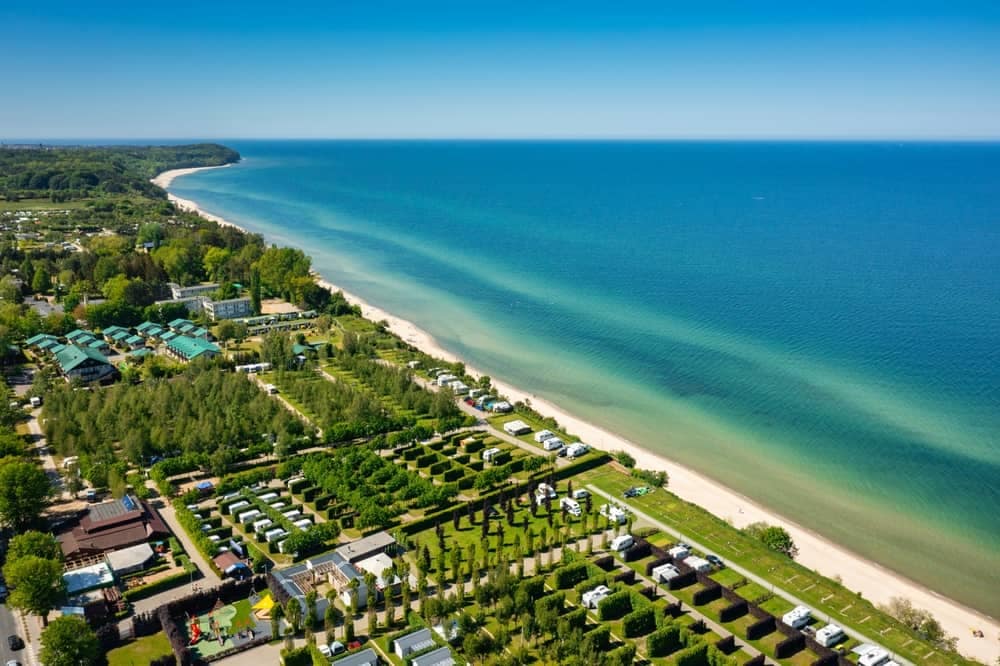 An aerial view of a European beach and trees, perfect for LeadingCampings enthusiasts who enjoy camping in scenic locations.