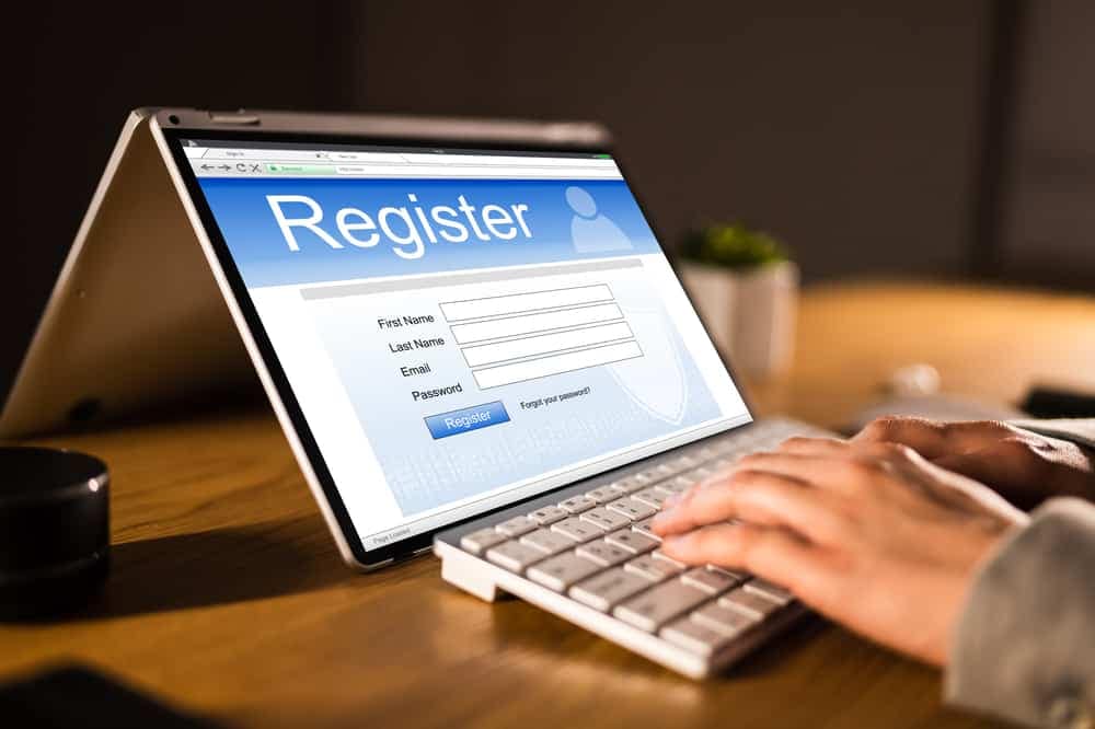 A person open registration on a laptop with the word register on it for the 32nd Annual event.