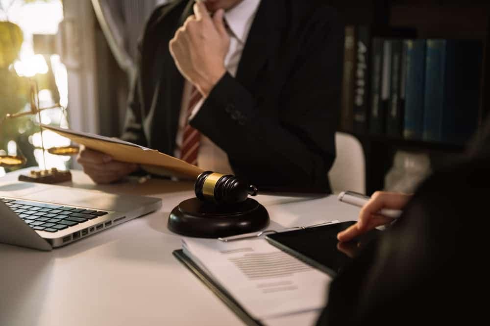 A lawyer is sitting at a desk during Congressional hearings.
