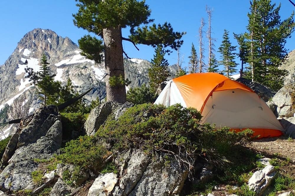 An orange tent sits on top of a rocky mountain in Eastern Idaho.