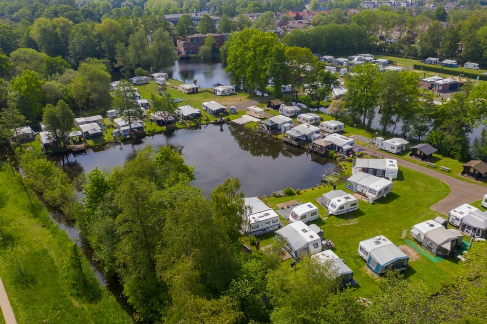 An aerial view of an RV park near a river offering expansive outdoor living.