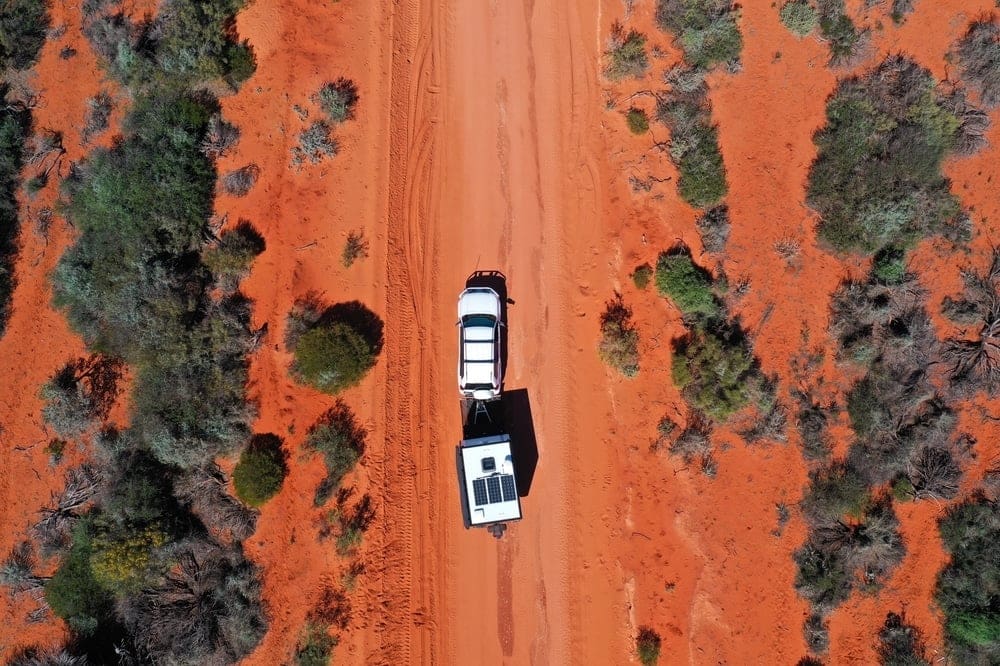 An aerial view of a truck driving down a dirt road in Australia.