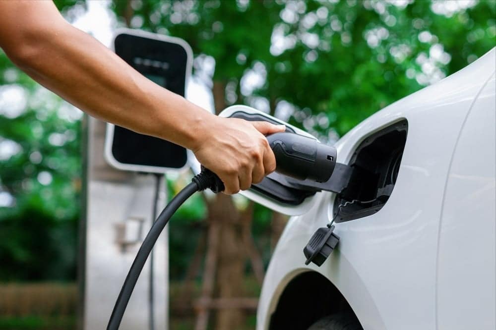 A person is charging an EV at a charging station.