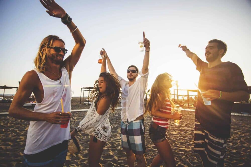 A group of friends having fun on the beach, defying the booze ban.