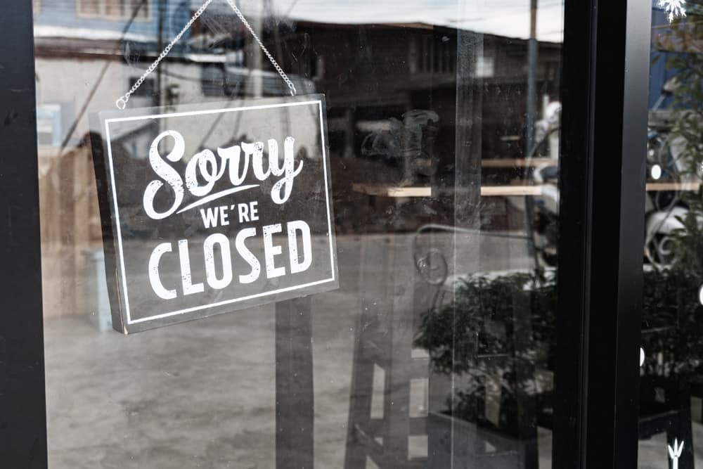 A sign that says sorry we're closed on a window, as village business owners in NZ are forced to close or walk away.