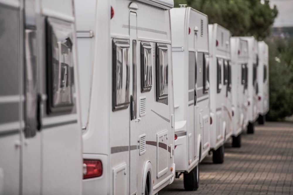 A row of white rvs parked next to each other.