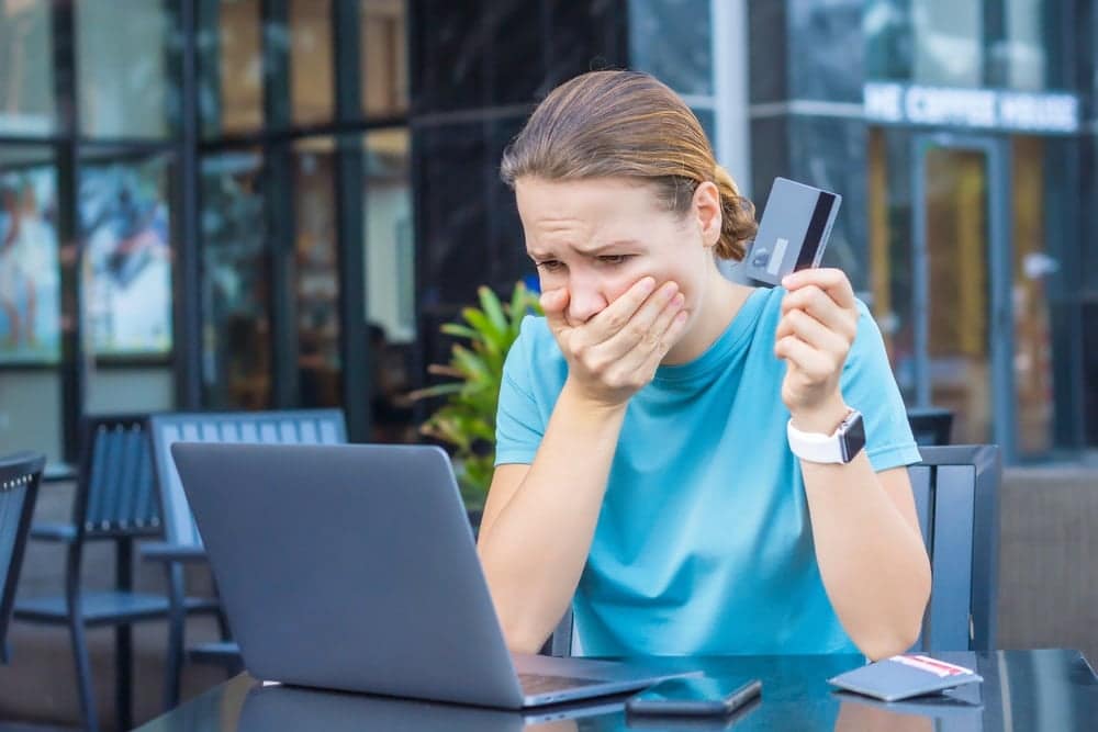 A woman sitting at a table with a laptop and credit card in Michigan.