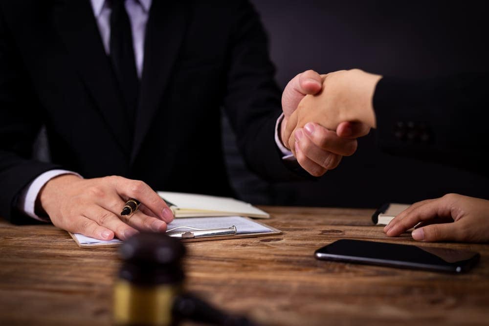 Two Policymakers from the Government Affairs Team of the RV Industry Association shaking hands at a table.