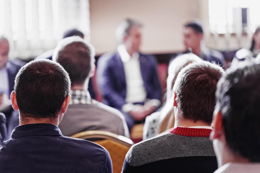 A group of people sitting in a conference room.