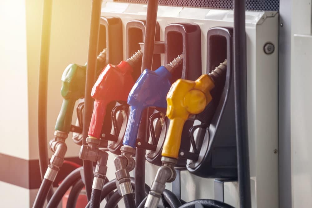 A group of gas pumps with different colored nozzles, offering various pump prices.