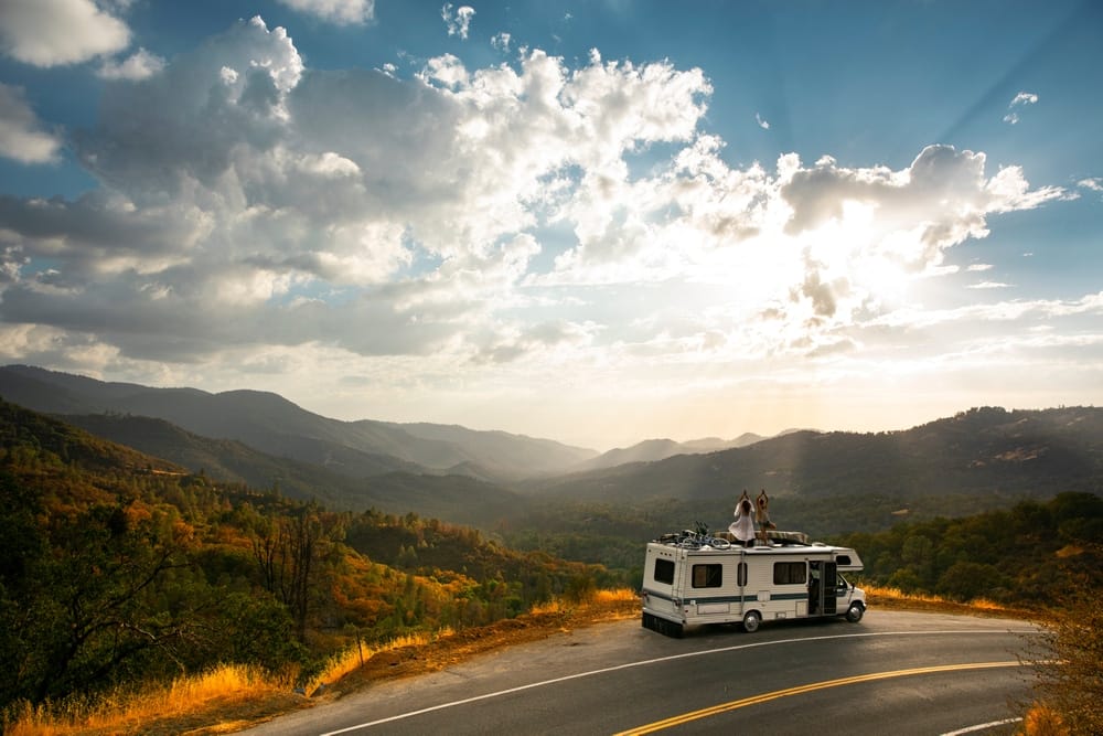 A Lazydays rv traveling down a winding road in the mountains.