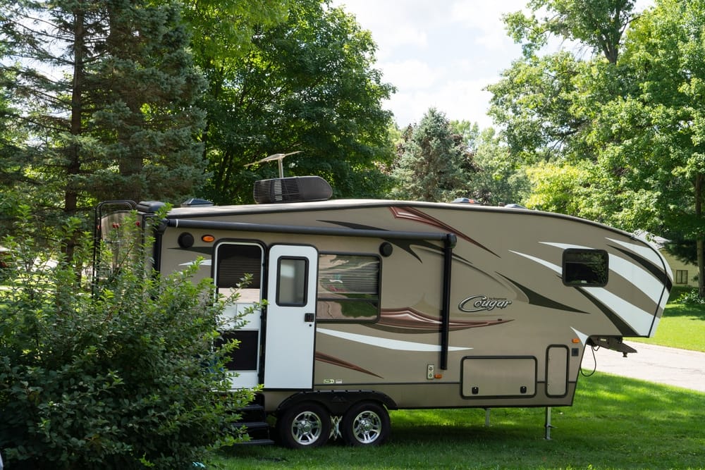 A brown and tan RV, perfect for RVers looking to explore new borders with the convenience of Harvest Hosts.
