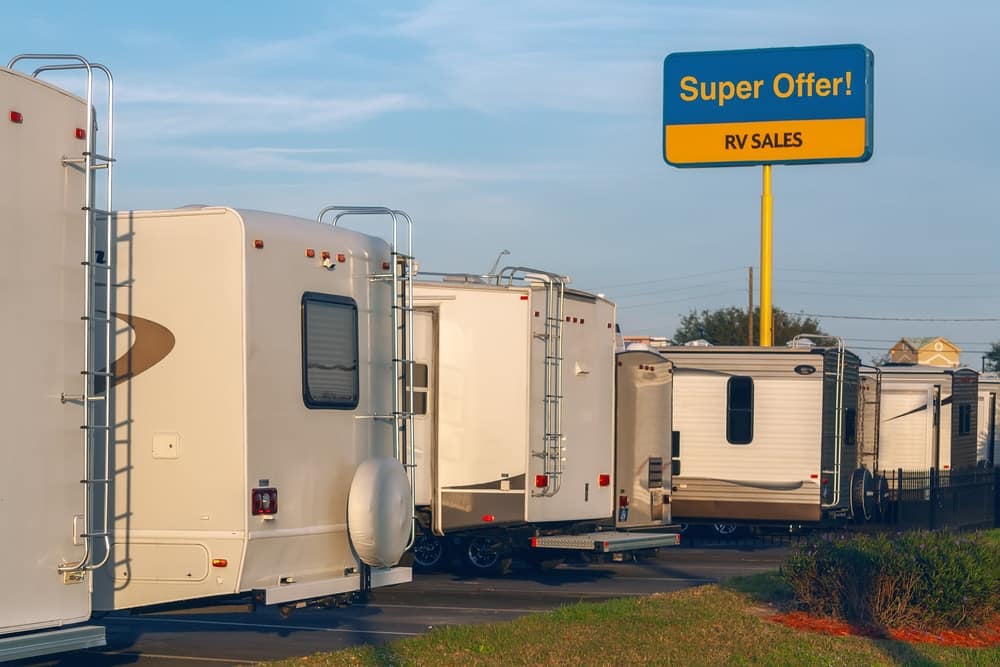A group of RVs, representing various RV Manufacturers/Brands, parked in a parking lot.