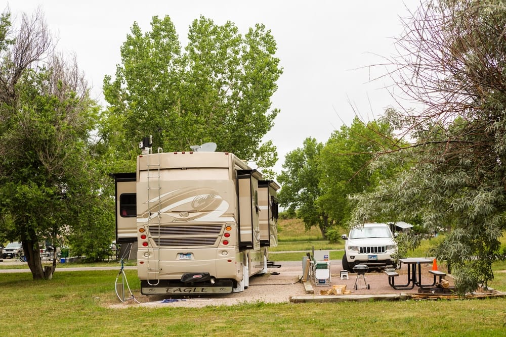 A specialty dealership modernizes a RV parked in a grassy area near trees, enhancing its motility.