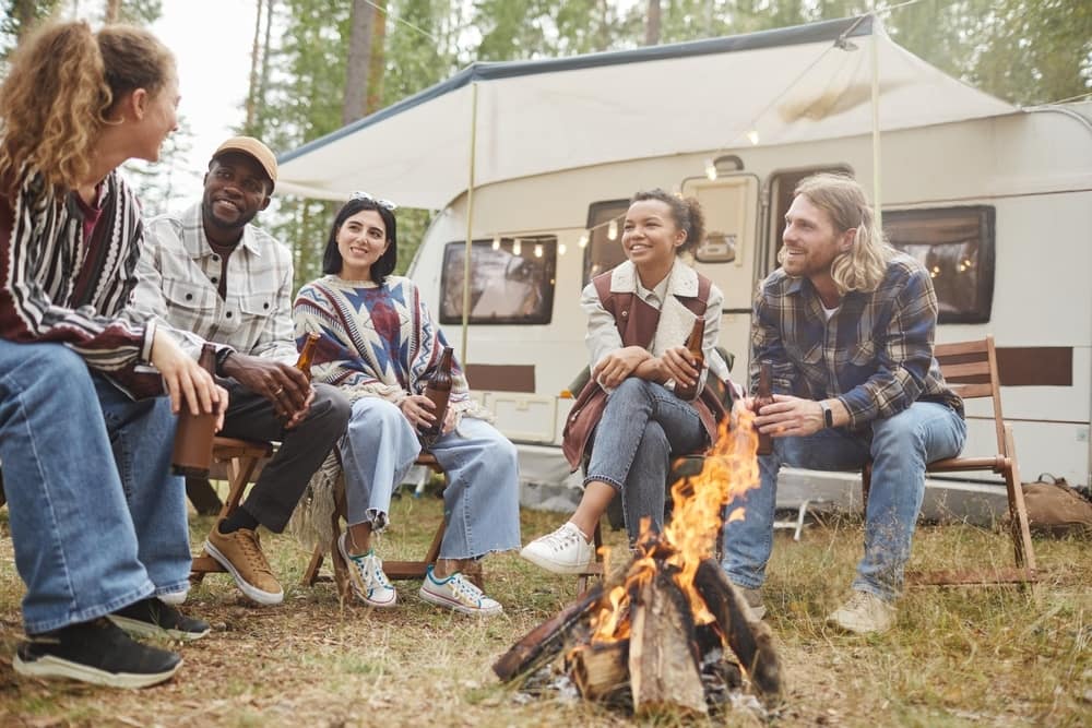 A diverse group of friends sitting around a campfire.