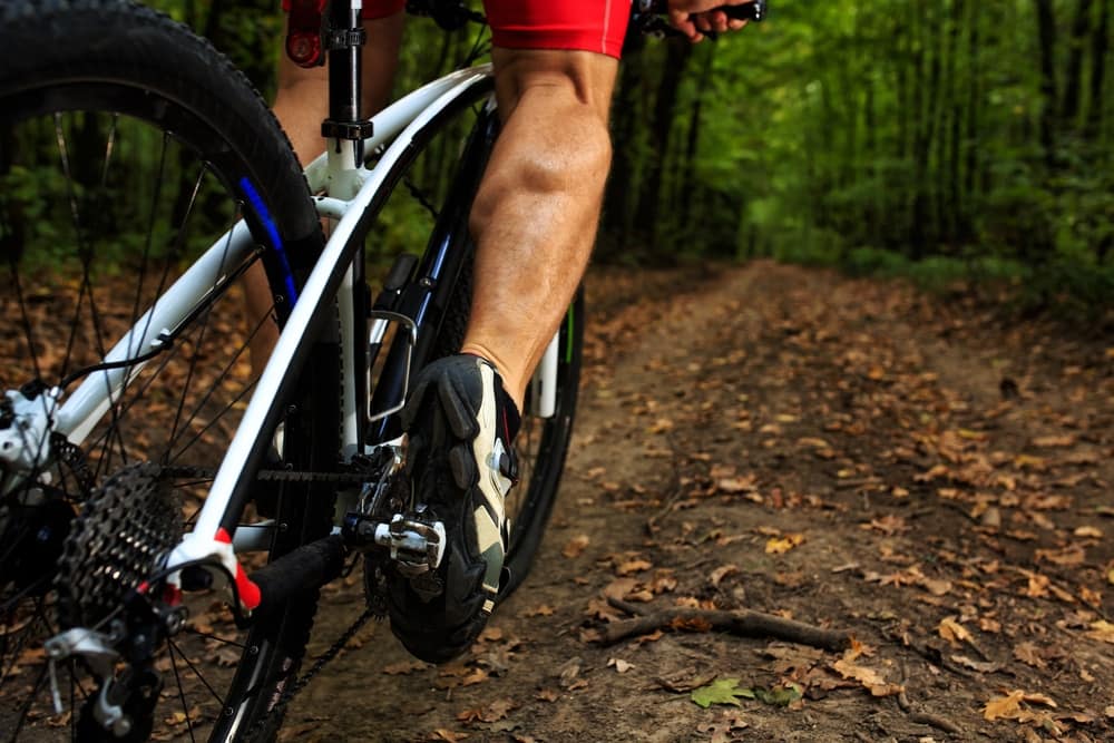 A person riding a mountain bike in the woods near a campground in Arkansas.