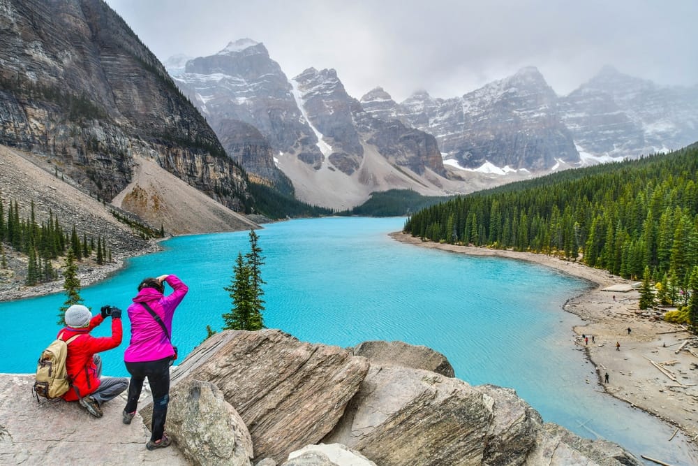 Two people capturing the beauty of a blue lake in the mountains at BC Parks.