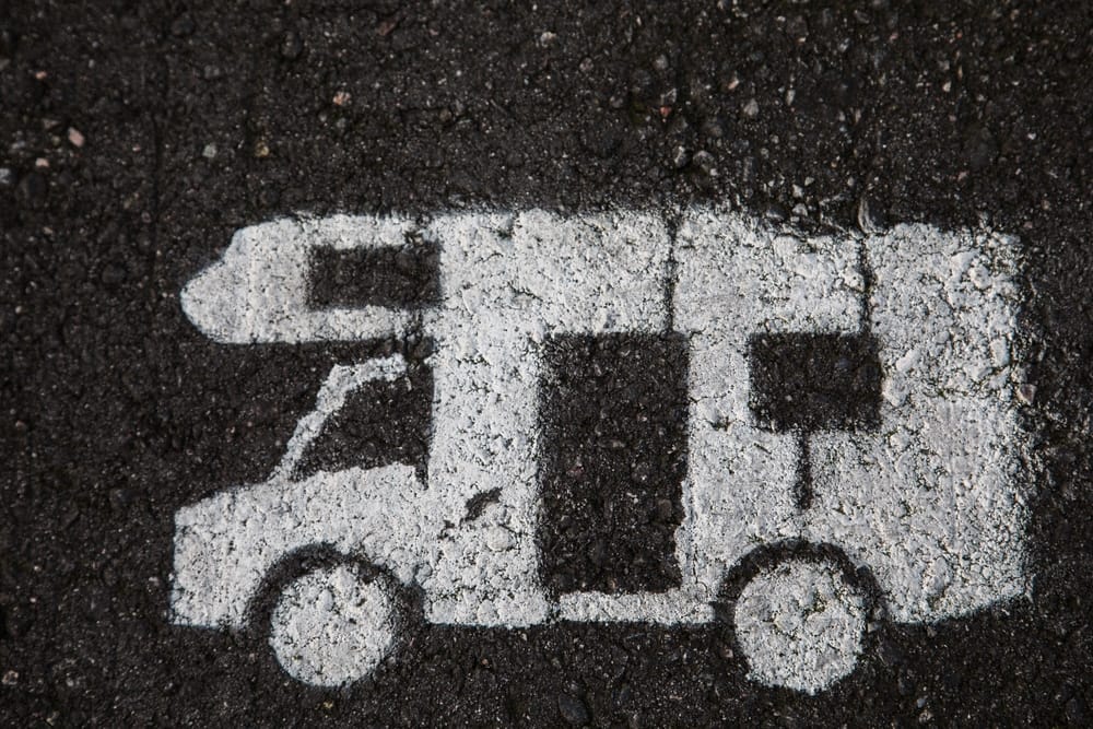 A white camper van is parked on the road in California City.